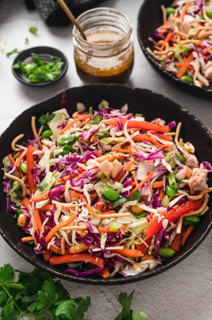 A dark round bowl filled with Asian cabbage salad.