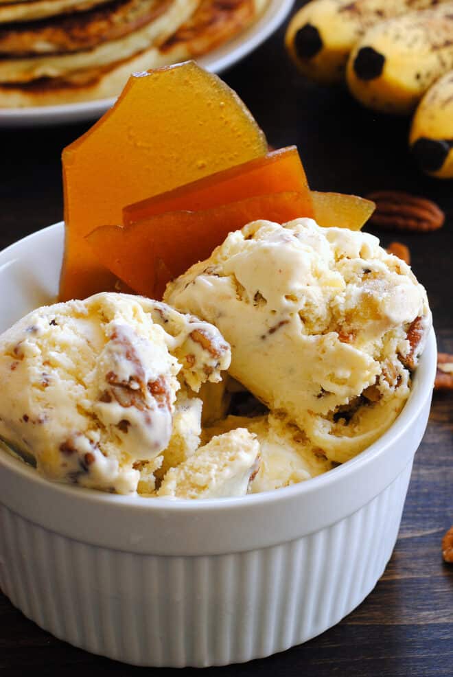 White ceramic bowl filled with nutty homemade gelato and garnished with brown brittle.