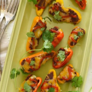 Black Bean Stuffed Mini Pepper Bites - A protein-packed snack, or fun party appetizer! Mini bell peppers stuffed with refried black beans and topped with cheese. | foxeslovelemons.com