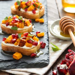 Butternut Squash & Pomegranate Crostini with Whipped Feta and Honey - This autumn appetizer is the perfect balance of sweet and savory. Set these out at your next party and watch them disappear! | foxeslovelemons.com