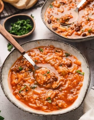 Two bowls of a cabbage roll soup recipe with spoons in them.