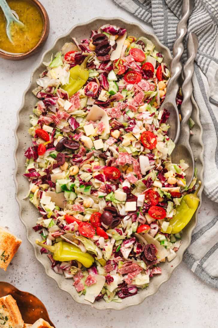 An Italian chopped salad on an oval platter with ruffled edges.