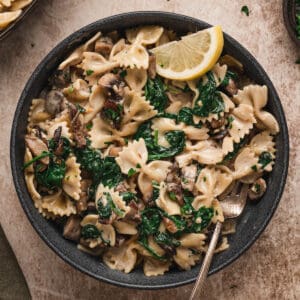 A dark bowl filled with creamy mushroom pasta.