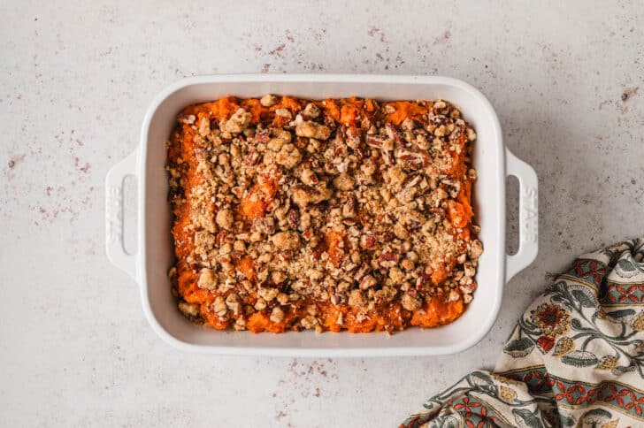 The best sweet potato casserole in a white baking dish.