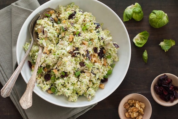 Fruit & Nut Brussels Sprout Slaw - A healthful and tasty coleslaw made with shredded brussels sprouts, dried cranberries and walnuts, tossed with a tangy yogurt-orange dressing! | foxeslovelemons.com