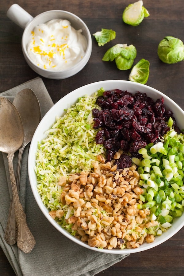 Fruit & Nut Brussels Sprout Slaw - A healthful and tasty coleslaw made with shredded brussels sprouts, dried cranberries and walnuts, tossed with a tangy yogurt-orange dressing! | foxeslovelemons.com