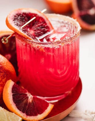 A blood orange margarita garnished with a slice of blood orange.