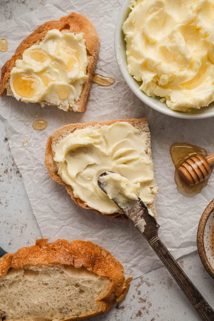 Bread spread with homemade butter and drizzled with honey.