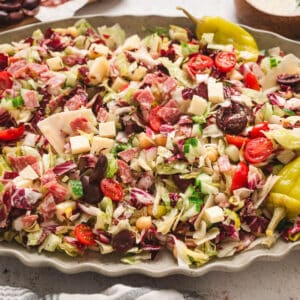 An Italian chopped salad on an oval platter with ruffled edges.