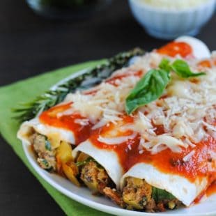 Italian Enchiladas - A tasty casserole (with hidden veggies!) the whole family will enjoy! Ground beef, Italian sausage, pepperoni, artichokes, spinach, mushrooms and ricotta cheese rolled up in flour tortillas, topped with marinara and mozzarella. | foxeslovelemons.com