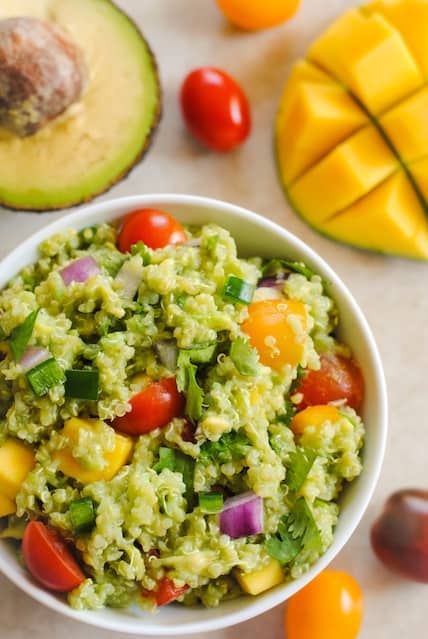 Guacamole Quinoa with Mango - all of the ingredients of guacamole, combined with quinoa and a little mango, for a tasty, healthy side dish! Serve warm or cold. | foxeslovelemons.com