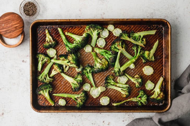 Roasted green brassica vegetables on a baking pan.