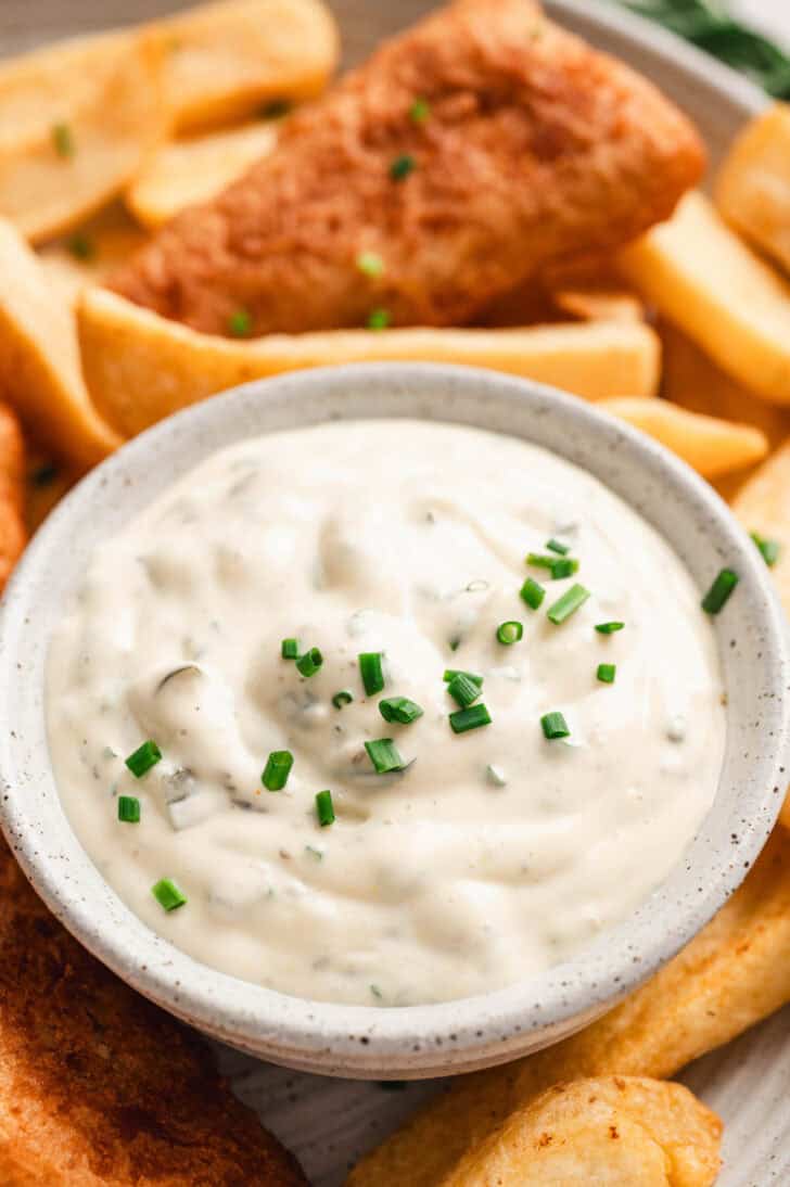 A small bowl of a tartar sauce recipe topped with chives.