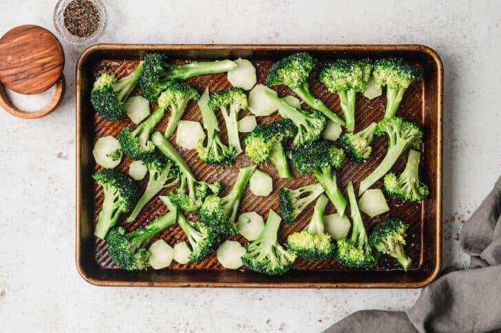 Green brassica vegetables on a rimmed baking pan.