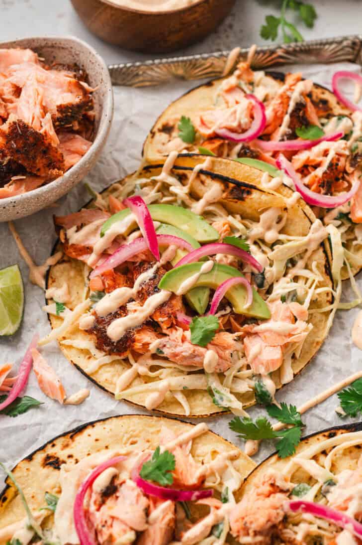 A salmon tacos recipe on a parchment-lined rimmed baking pan.