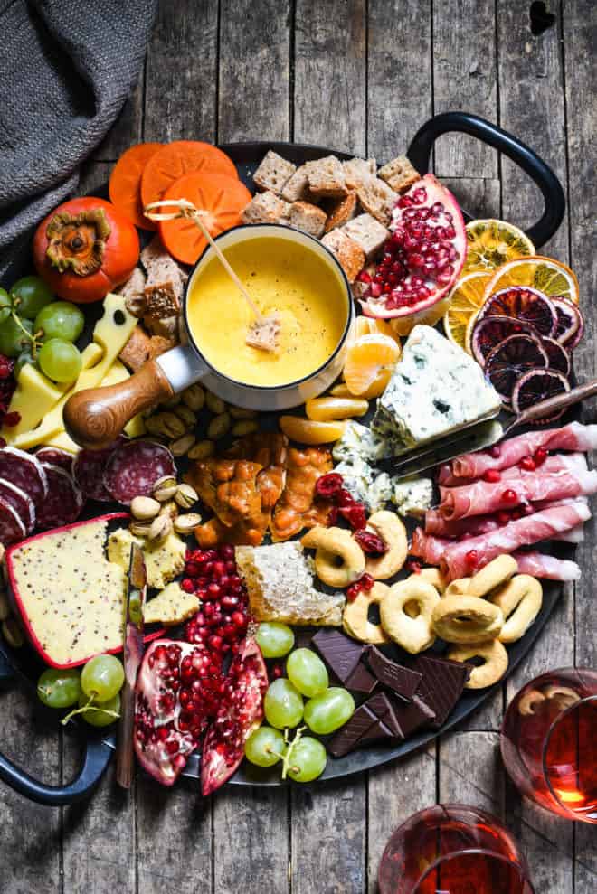 Winter Cheese Board with German Beer Cheese Fondue - Celebrate the season with this big, beautiful platter of cheese, charcuterie, bread, seasonal fruits and sweet treats. | foxeslovelemons.com